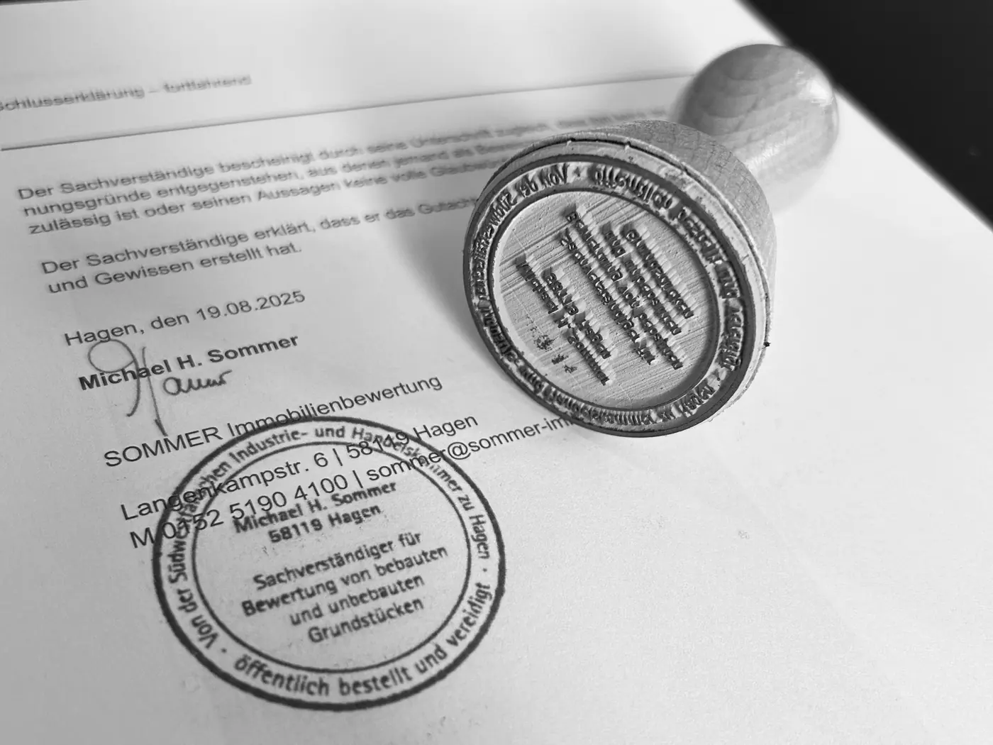 Rundstempel des öffentlich bestellten und vereidigten Sachverständigen auf einem unterschriebenen Gutachten